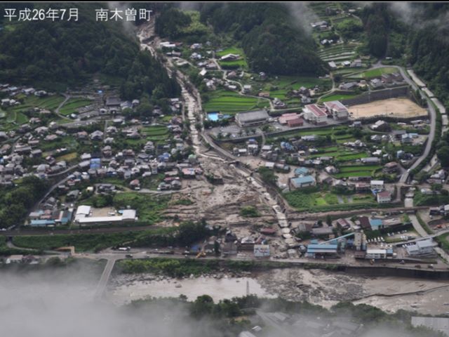 川沿いに土石流が流れ、扇状に溢れ出している写真。