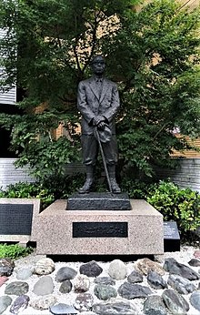 杖をもって立つ赤木正雄博士の像
周囲には各地から供出された石が並べられている。