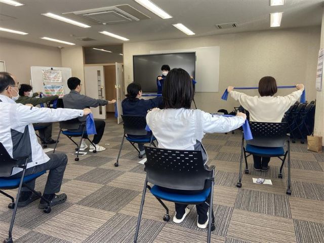 ゴムチューブを両腕で引っ張っている様子