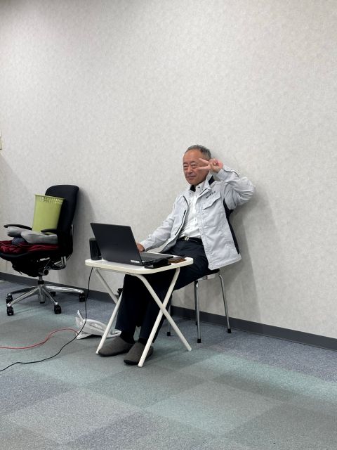 テレワーク準備を終え、仮設デスクに座り、ノートパソコンで仕事をするT常務